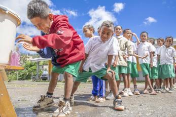 Children line up to wash their hands before eating lunch at school in maubisse villa, timor-leste.
